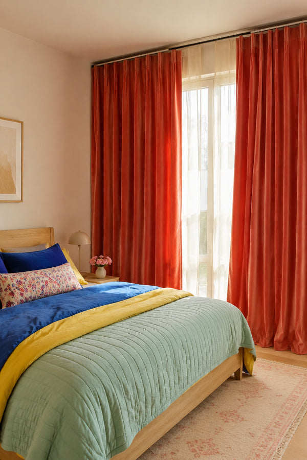 Neutral bedroom with coral velvet curtains cobalt bedding and a mint quilt
